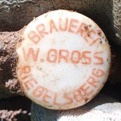 gefunden am 26. Juli 2020 in Schiffweiler am Schiffweiler Mühlbach/Fahrbach
Verschluss einer Bierflasche der Brauerei W. Gross, Riegelsberg
Die Brauerei Wilhelm Gross geht 1986 in der Karlsberg Brauerei auf, ab 1987 wird der Betrieb eingestellt. Der Verschluss dürfte aus den 1970er Jahren stammen.