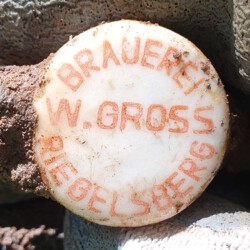 gefunden am 26. Juli 2020 in Schiffweiler am Schiffweiler Mühlbach/Fahrbach
Verschluss einer Bierflasche der Brauerei W. Gross, Riegelsberg
Die Brauerei Wilhelm Gross geht 1986 in der Karlsberg Brauerei auf, ab 1987 wird der Betrieb eingestellt. Der Verschluss dürfte aus den 1970er Jahren stammen.